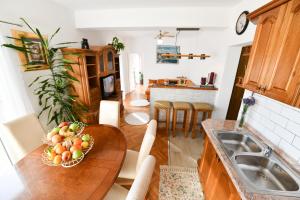 a kitchen with a table with a bowl of fruit on it at Apartman PIK in Karlobag