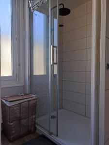 a shower with a glass door in a bathroom at Maison de ville au calme in Cognac +3 photos