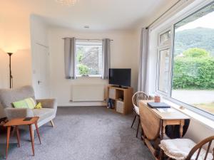 a living room with a couch and a table and a window at Rock Cottage in Keswick