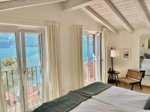 a bedroom with a bed and a large window at The Wee House on the Lake in Carate Urio