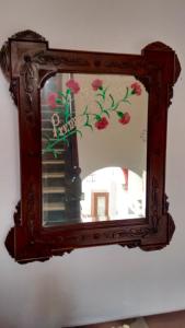 Un espejo colgando de una pared con flores. en Casa del Regidor, en El Puerto de Santa María