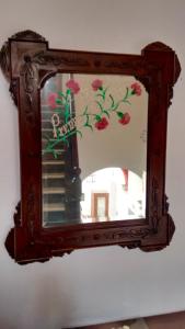 a mirror hanging on a wall with flowers on it at Casa del Regidor in El Puerto de Santa María