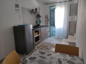 a kitchen with a refrigerator and a table in it at Porta Noa in Veglie