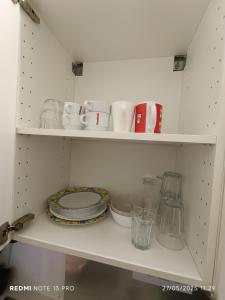 een witte kast met borden, bekers en borden bij City Center ground floor in Oostende +6 foto's