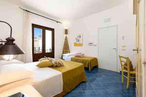 una camera d'albergo con due letti e una finestra di A' Cavalera a San Vito lo Capo