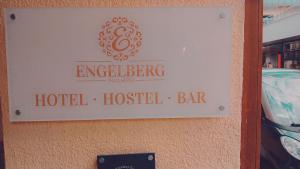 a sign for a hotel hostel bar on a wall at Hostel Engelberg "mein Trail Hostel" in Engelberg