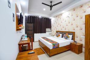 a bedroom with a bed and a room with a ceiling at FabHotel Frolic Luxury Stay in Noida +26 photos