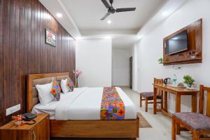 a bedroom with a bed and a desk and a tv at FabHotel Frolic Luxury Stay in Noida