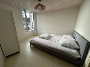 a bedroom with a bed with white sheets and pillows at Idéal famille - Proche sites touristiques in Moncoutant