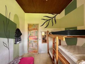 a room with two bunk beds and a door at Habitat Marajó Hostel e Turismo in Soure