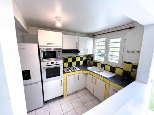 a small kitchen with yellow and white appliances at Villa plaisir de vivre in Petit-Bourg +21 photos