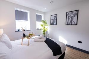 a white bedroom with a large bed and windows at Brand-New Borehamwood 1-Bed, 1-Bath Flat in Borehamwood +33 photos