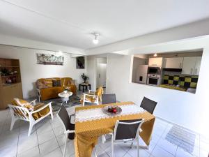 a dining room and living room with a table and chairs at Villa plaisir de vivre in Petit-Bourg