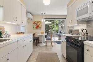 a kitchen with white cabinets and a black stove top oven at Coastal Comfort Near Orleans Adventures in Orleans