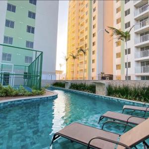 a swimming pool with benches and some buildings at Ap 2 quartos ,condomínio mirante clube in Fortaleza