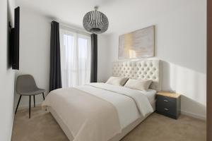 una camera da letto bianca con un letto grande e una sedia di Mill Hill 2 Bed Apartment a Mill Hill