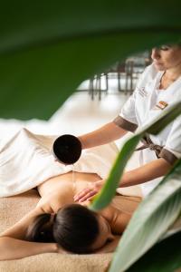 Una mujer recibiendo un masaje de un terapeuta. en Corona Dolomites Hotel, en Andalo