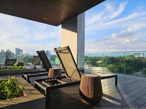 Un balcón con sillas y vista a una ciudad. en The Establishment - Menara Teguh Bangsar, en Kuala Lumpur