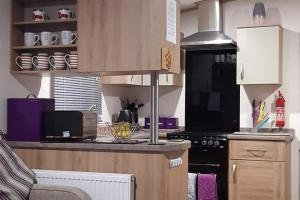 a kitchen with a counter and a stove top oven at Purple Palace 3-Bed Caravan Ingoldmells in Ingoldmells +11 photos