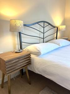 a bedroom with a bed with a lamp on a night stand at Spacious two bedrooms apartment for business and holiday in Portsmouth