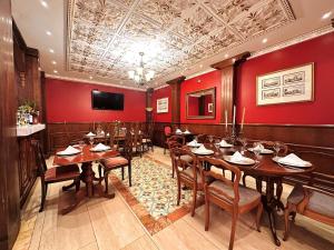 a restaurant with wooden tables and chairs and a television at San Juan Hotel in Cuenca