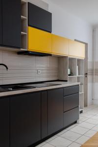 a kitchen with black and yellow cabinets and a sink at MOBstar in Alba Iulia