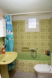 a bathroom with a tub and a toilet and a sink at Anna's Traditional House Pandeli in Panteli +18 photos