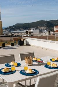 een tafel met borden eten op het dak bij Casa Nau - with pool and sea view in Sesimbra