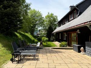 une terrasse avec une table et des chaises à côté d'une maison dans l'établissement Schwarzwald Apartment mit Weitblick - Villa Hubertus, à Feldberg
