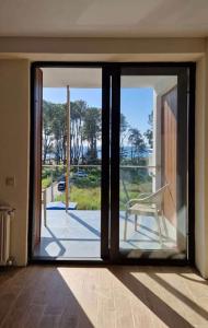 an open glass door with a chair on a balcony at Terrace Kapro-one in Itʼkhvisi