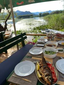 a table with a plate of food with a fish on it at Apartman Skadarsko jezero bay in Vranjina
