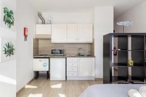 a small kitchen with white cabinets and a microwave at Cabanas de Tavira - Studio in Cabanas de Tavira