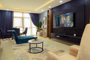 a living room with a couch and a tv at Terraform Hotel in Lagos
