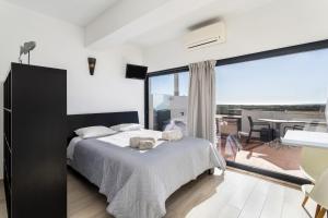 a bedroom with a large bed and a dining room at Cabanas de Tavira - Studio in Cabanas de Tavira
