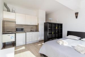 a bedroom with two beds and a kitchen with white cabinets at Cabanas de Tavira - Studio in Cabanas de Tavira +15 photos