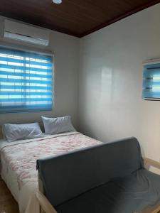 a bed in a room with a window and a bed sidx sidx sidx at MNM Apartments cruz in Tanauan