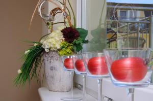 a table with three glasses and a vase with flowers at Villa Savana in Mielno
