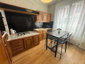 a kitchen with a table with chairs and a stove at Grand T3 90m2 Haussmanien avec suite en centre ville et parking TOUT inclus in Orléans