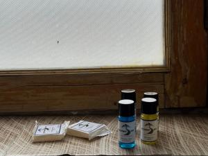 two spray bottles sitting on the floor next to a door at Highway Inn Guest House in Leh
