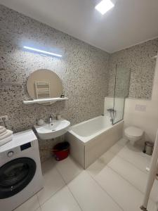 a bathroom with a sink and a washing machine at West Homes 34 in Oradea