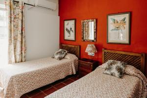 two beds in a room with red walls at Casa campo privada con piscina a 15 min playas Dehesa de las Yeguas in Cádiz +40 photos