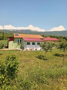 una casa en un campo con montañas al fondo en Kamp sv.Jovan, en Pirot