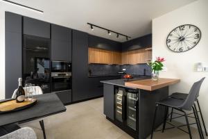 a kitchen with black cabinets and a clock on the wall at Luxury Penthouse Viki with seaview in Umag