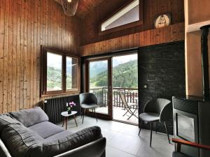 a living room with a couch and chairs and windows at Appartement rénové 8 pers avec balcon, Le Grand-Bornand - FR-1-458-138 in Le Grand-Bornand