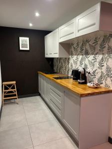 a kitchen with white cabinets and a counter top at Na Zaciszu - apartament z jacuzzi in Szczytna