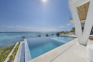 a swimming pool with a view of the ocean at Spectacular New Oceanfront Villa Isla Mujeres in Isla Mujeres