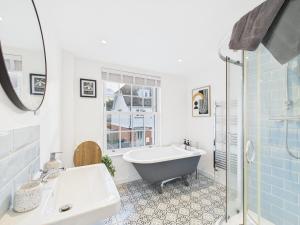 a bathroom with a tub and a sink and a shower at Corner House- hot tub and outdoor fireplace in Herstmonceux +39 photos