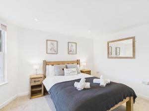 a bedroom with a bed with two towels on it at Corner House- hot tub and outdoor fireplace in Herstmonceux