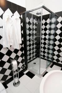 un bagno bianco e nero con doccia e lavandino di Hostal Santo Domingo a Madrid