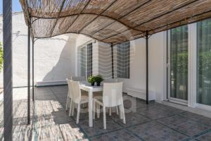 a patio with a white table and chairs on it at Villa Odysea - spiaggia a 150m By Cala Salento in Torre Lapillo